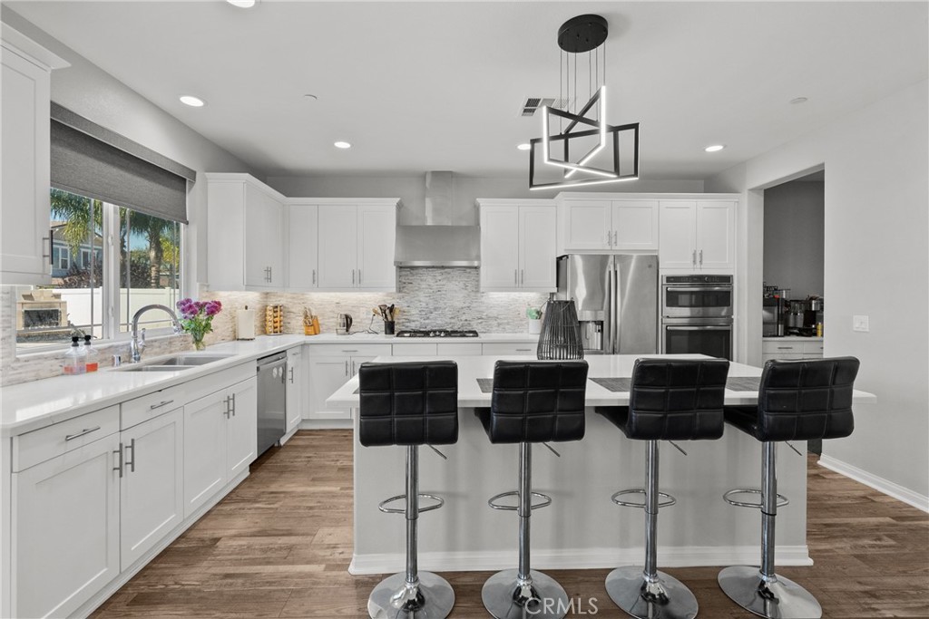 232 River Street Fillmore, CA 93015 - Photo 16 of 61 a kitchen with stainless steel appliances kitchen island granite countertop a stove a sink a refrigerator and white cabinets