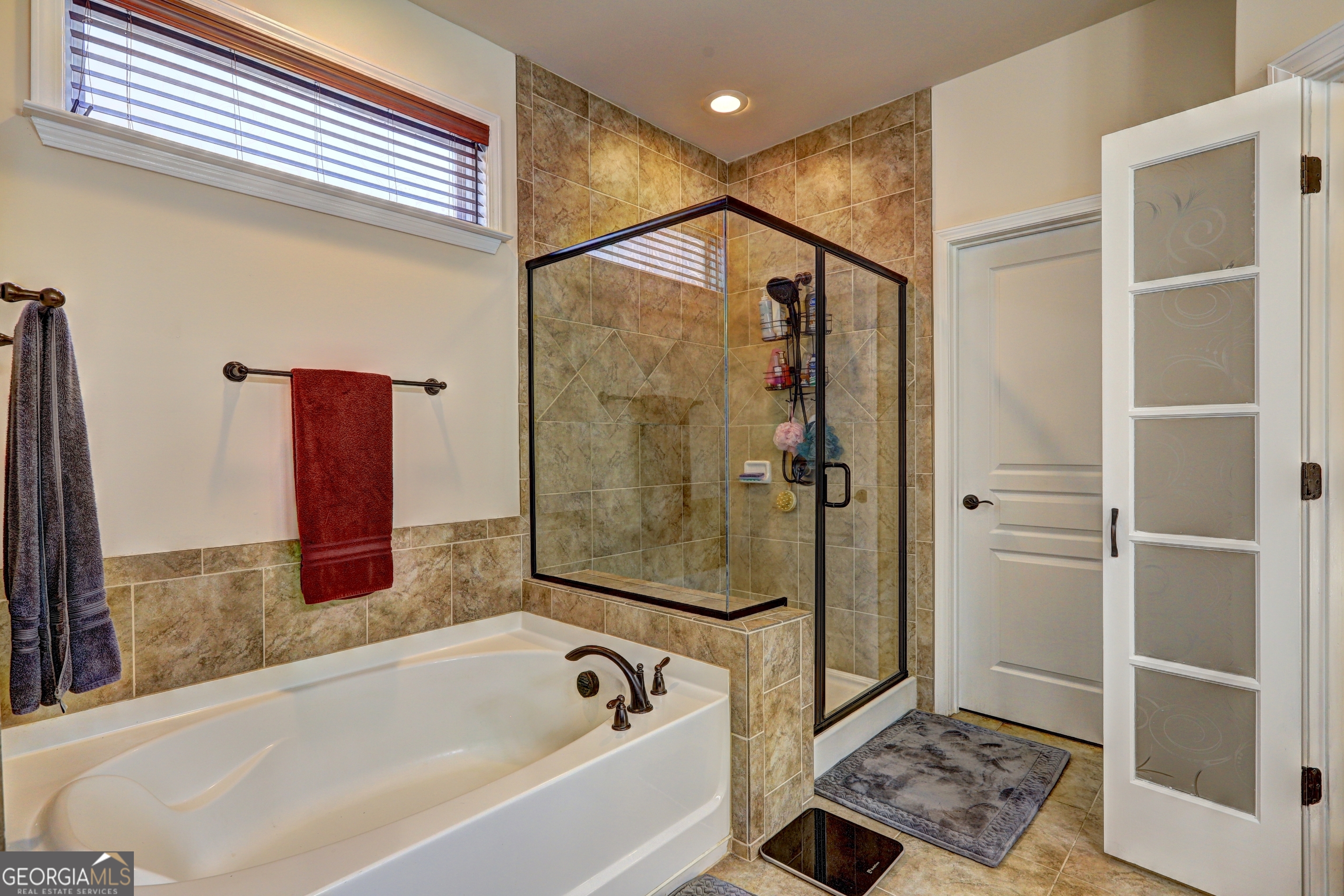 757 Firefly Court Griffin, GA 30223 - Photo 21 of 31 a bathroom with a bathtub and a shower