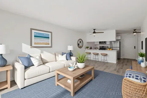 a living room with stainless steel appliances furniture and a wooden floor