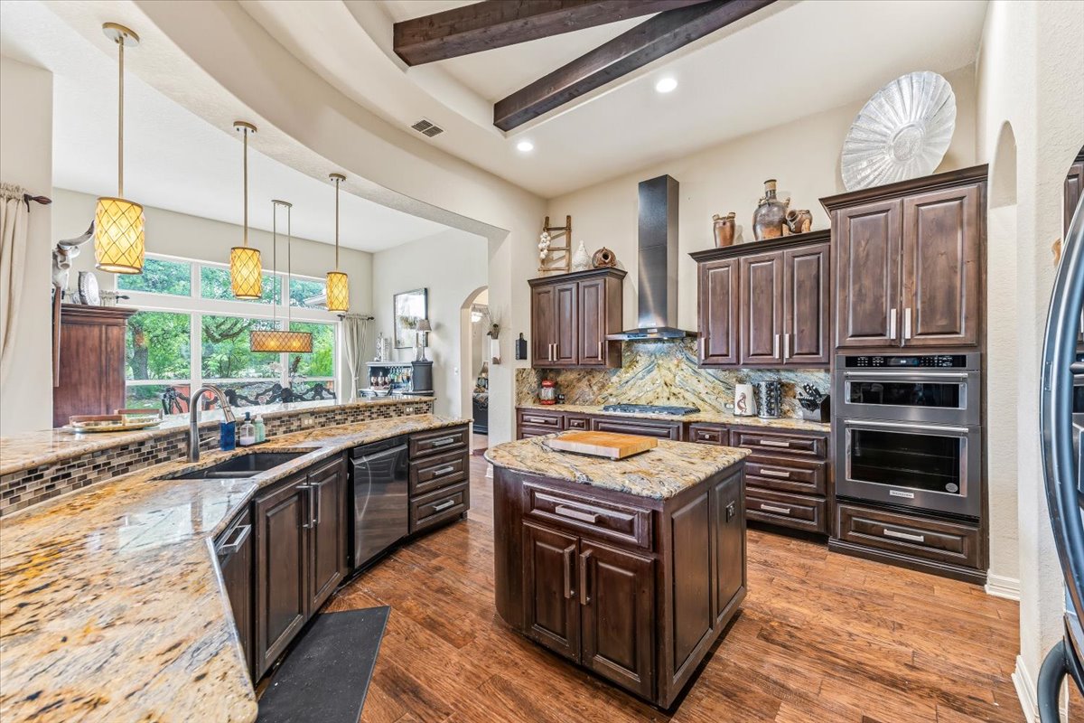1930 Rothschild New Braunfels, TX 78132 - Photo 11 of 39 The kitchen features rich wood cabinetry, granite countertops, and stainless steel appliances including a double oven and range hood