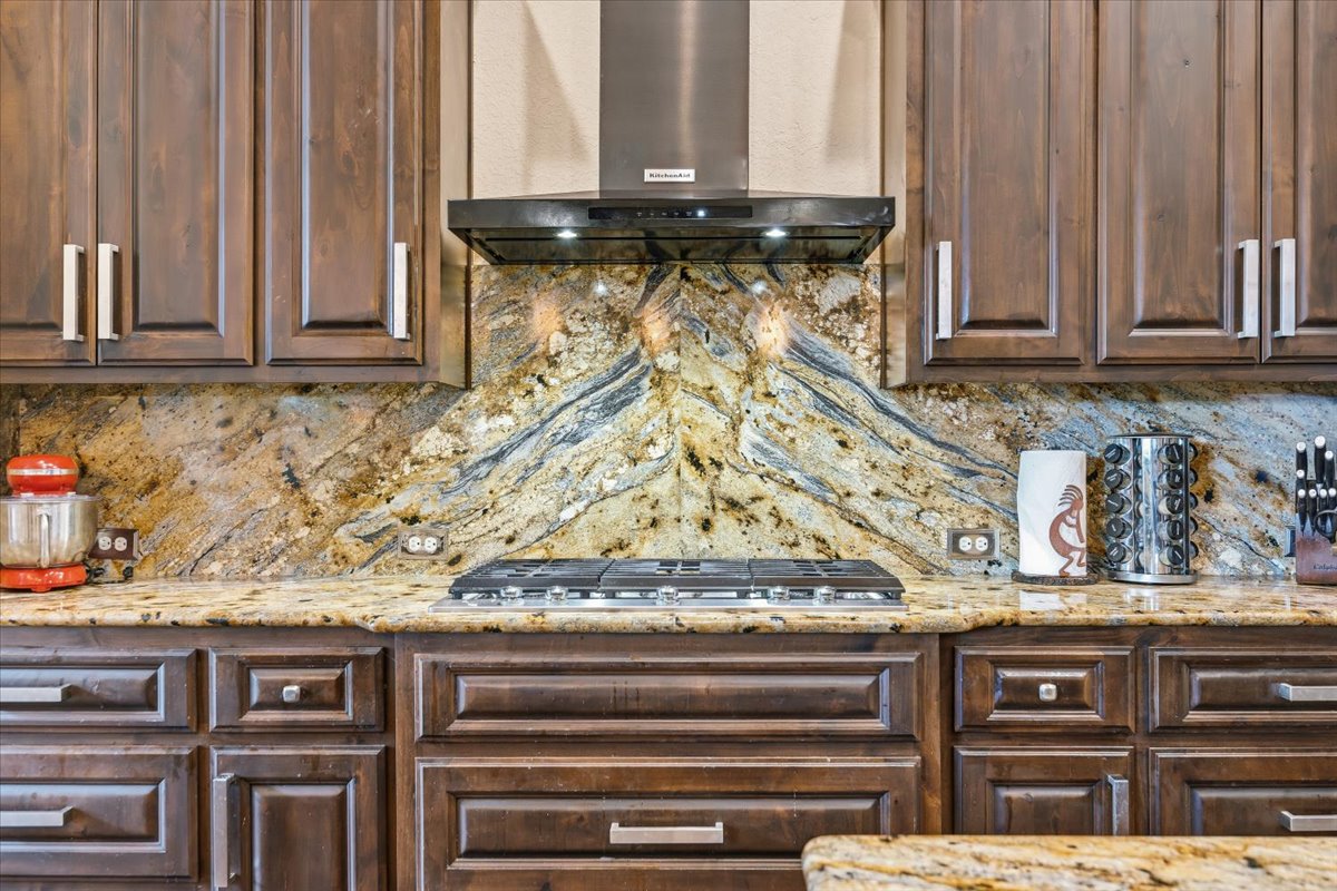 1930 Rothschild New Braunfels, TX 78132 - Photo 15 of 39 Kitchen featuring dark wood cabinetry, granite countertops, a gas cooktop, and a stainless steel range hood