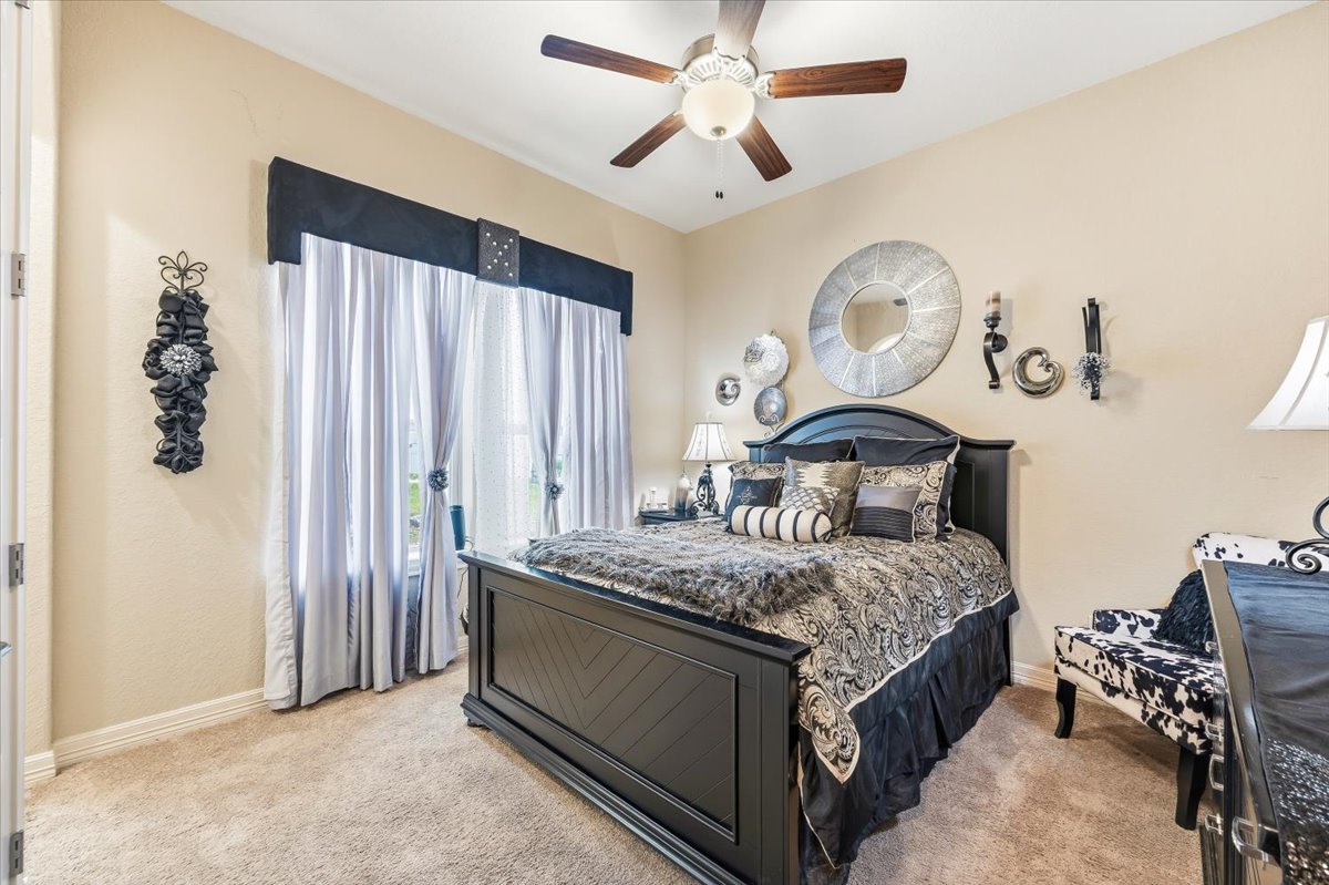 1930 Rothschild New Braunfels, TX 78132 - Photo 17 of 39 This bedroom features plush carpet flooring, a ceiling fan with integrated lighting, and a window with elegant drapery