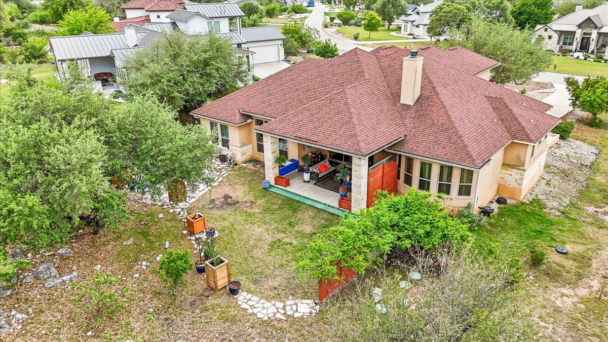 1930 Rothschild New Braunfels, TX 78132 - Photo 37 of 39 The property features a red shingled roof, a chimney, and a covered back patio