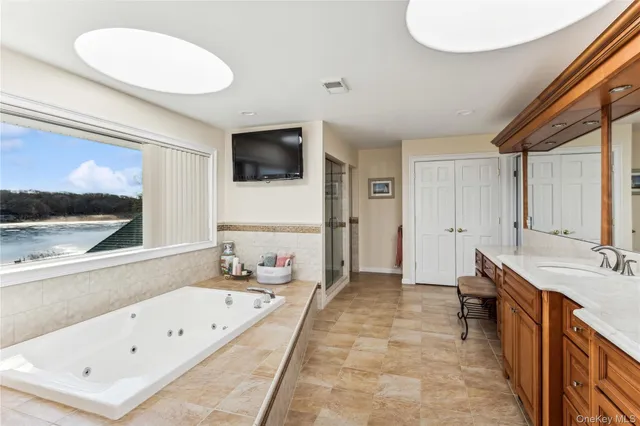 a spacious bathroom with a tub a double vanity sink and a mirror