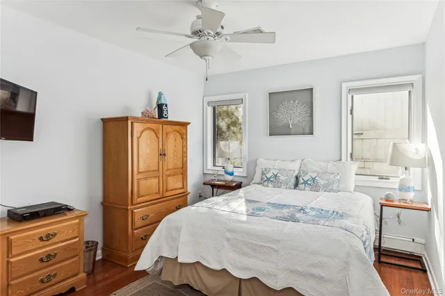 a bedroom with a bed and a flat tv screen on the dresser