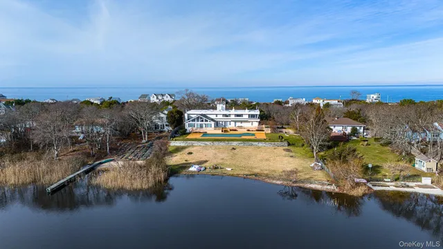 an aerial view of residential houses with outdoor space and lake view