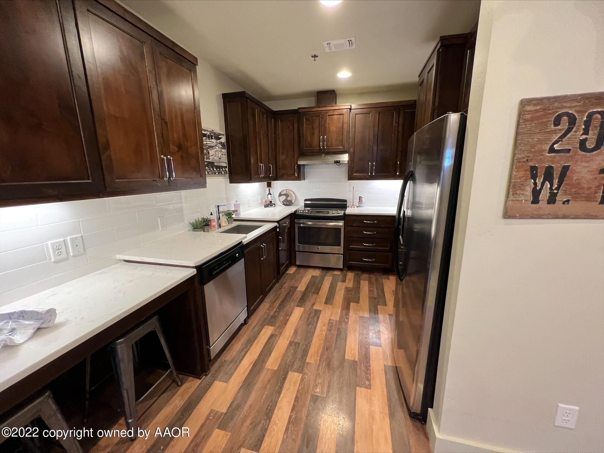 Southeast 10th Amarillo, TX 79101 - Photo 2 of 10 a kitchen with sink refrigerator and cabinets