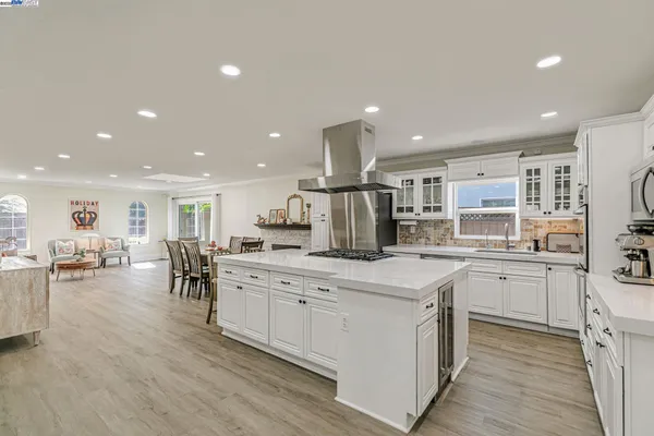 a large kitchen with kitchen island a sink a center island stainless steel appliances and cabinets