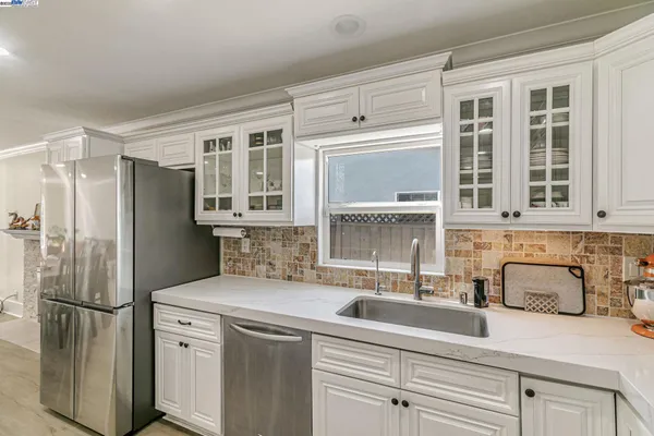 a kitchen with stainless steel appliances white cabinets and a refrigerator