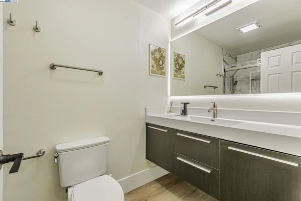 a bathroom with a toilet a sink a mirror and vanity