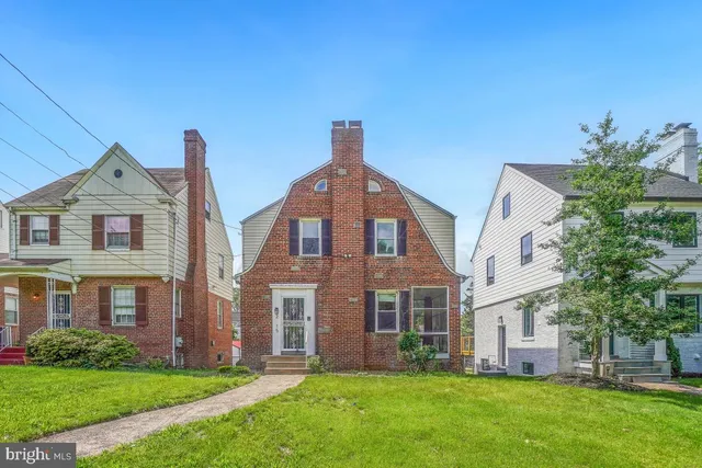 a front view of a brick house with a yard