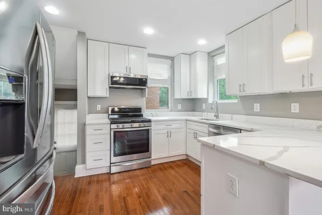 a kitchen with stainless steel appliances granite countertop a stove a sink and a refrigerator