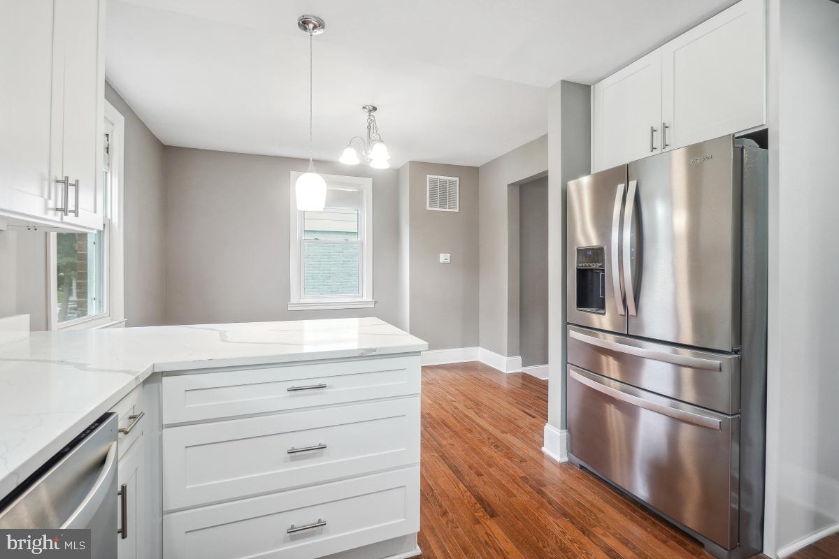 2615 Otis Street Northeast Washington, DC 20018 - Photo 15 of 45 a kitchen with kitchen island a counter top space wooden floor and stainless steel appliances