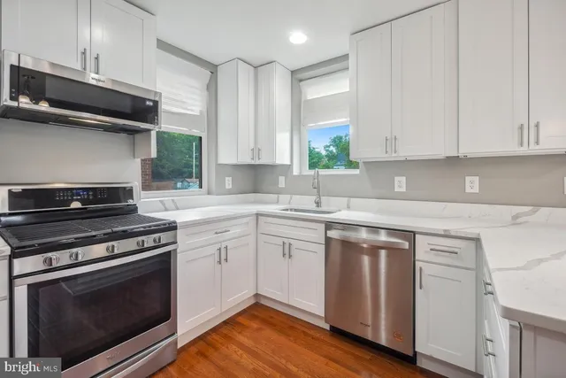 a kitchen with cabinets appliances and a wooden floor