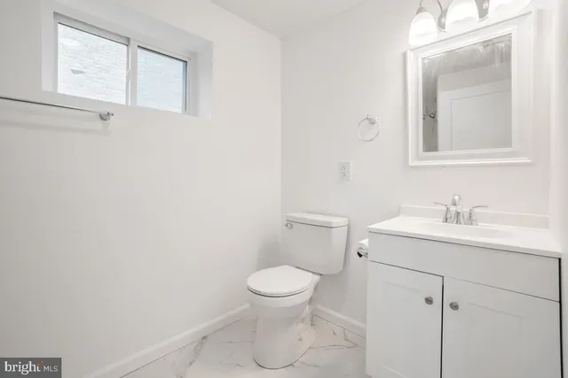 a bathroom with a toilet a sink and mirror