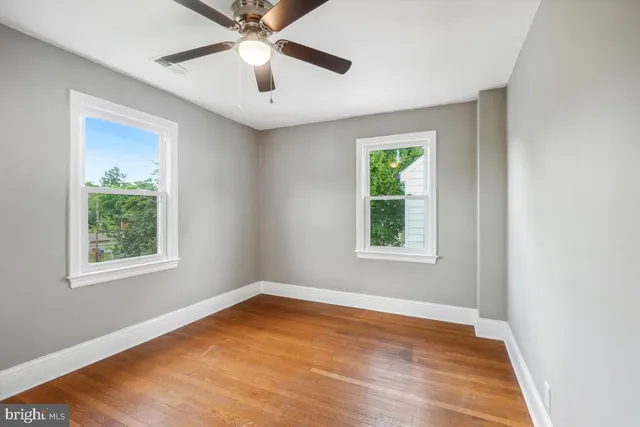 an empty room with window and fan