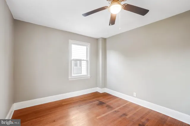 an empty room with a window and a fan