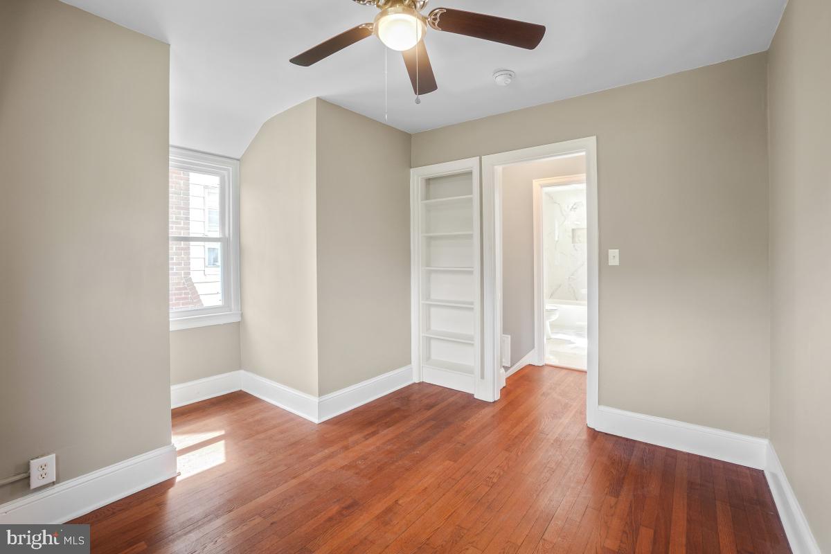 2615 Otis Street Northeast Washington, DC 20018 - Photo 35 of 45 an empty room with wooden floor chandelier fan and windows