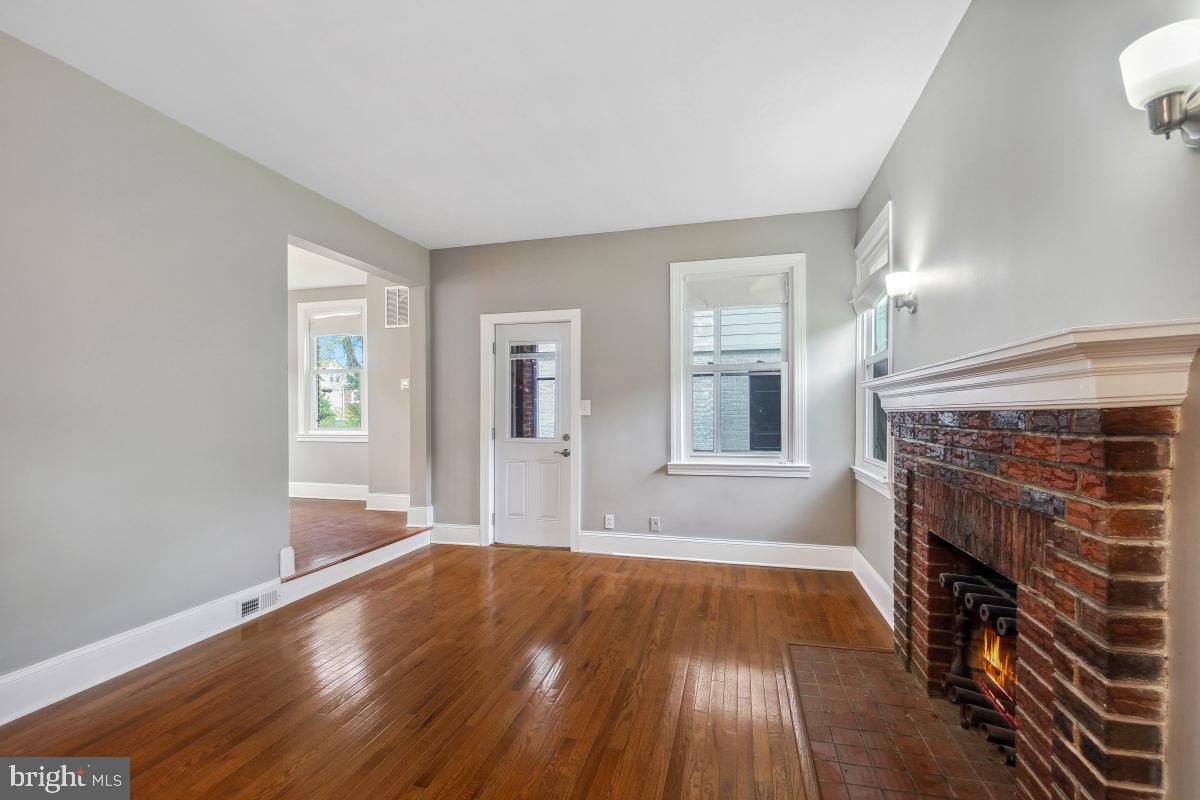 2615 Otis Street Northeast Washington, DC 20018 - Photo 6 of 45 a view of empty room with wooden floor and fireplace