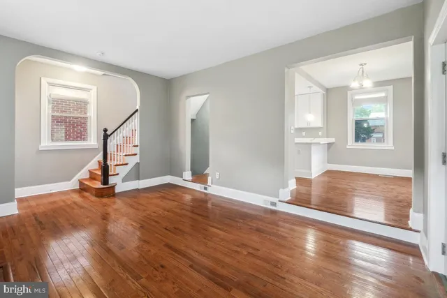 a view of empty room with wooden floor and windows