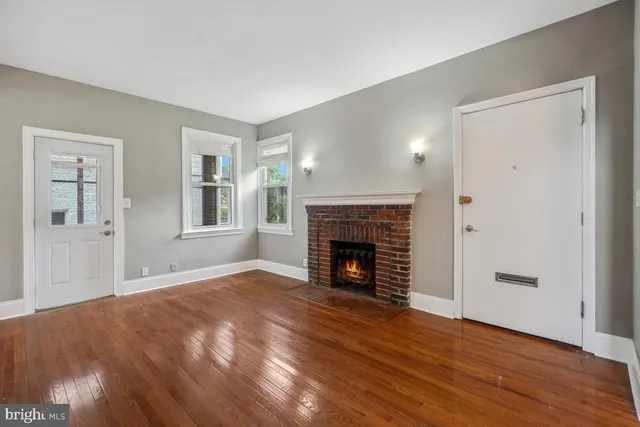 a view of empty room with wooden floor and fireplace