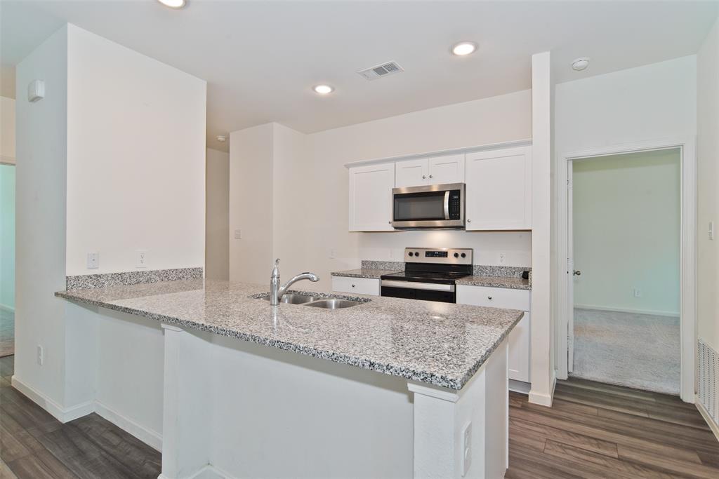 1637 Shadow Hawk Drive Fort Worth, TX 76052 - Photo 5 of 20 a kitchen with granite countertop kitchen island a sink appliances and cabinets