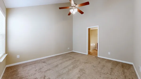 an empty room and chandelier fan