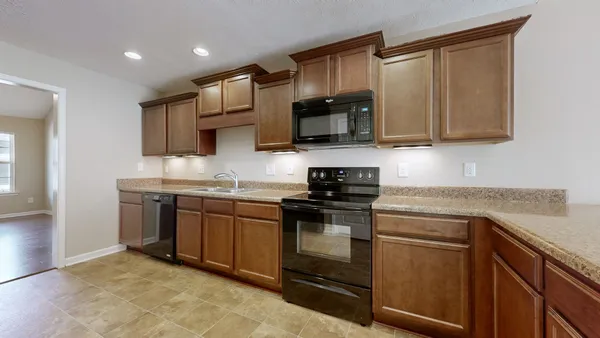 a kitchen with stainless steel appliances granite countertop a stove top oven a sink dishwasher and a microwave oven on the blue kitchen countertops