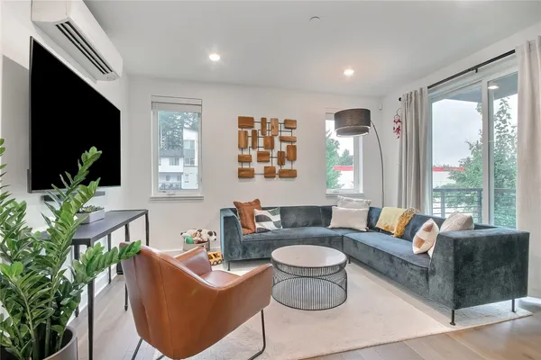 a living room with furniture a flat screen tv and a large window