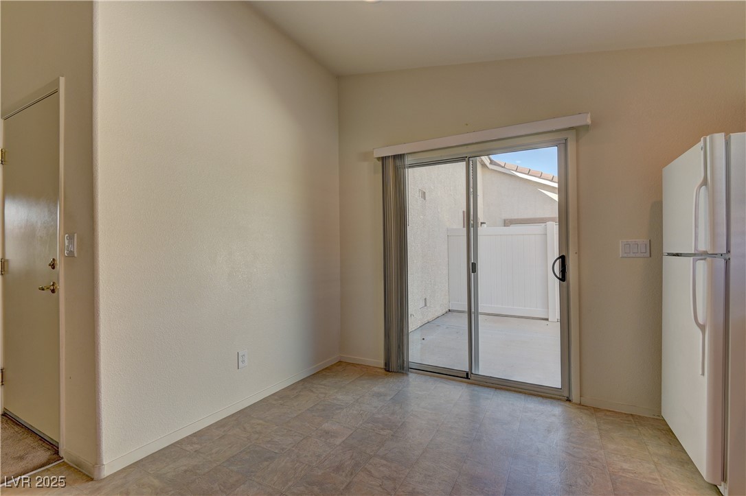 10403 Madagascar Palm Street Las Vegas, NV 89141 - Photo 13 of 21 Empty room featuring baseboards and lofted ceiling