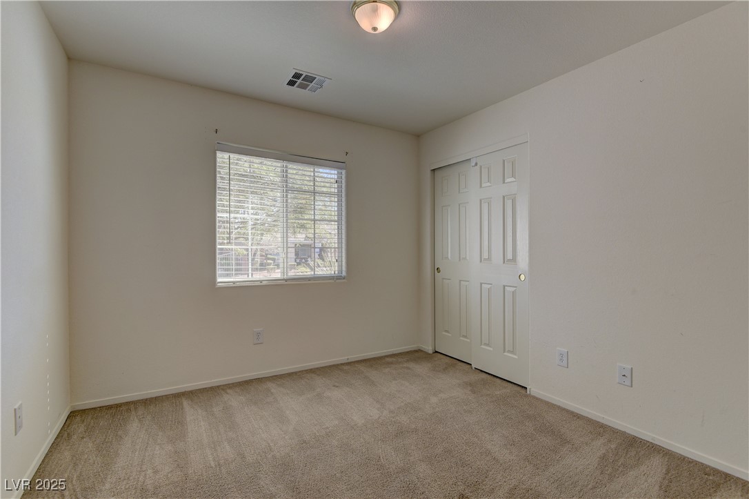 10403 Madagascar Palm Street Las Vegas, NV 89141 - Photo 18 of 21 Unfurnished bedroom with light colored carpet and a closet