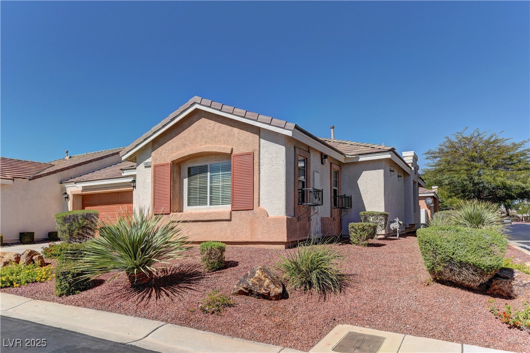 10403 Madagascar Palm Street Las Vegas, NV 89141 - Photo 3 of 21 View of front of property with stucco siding, a tile roof, and a garage
