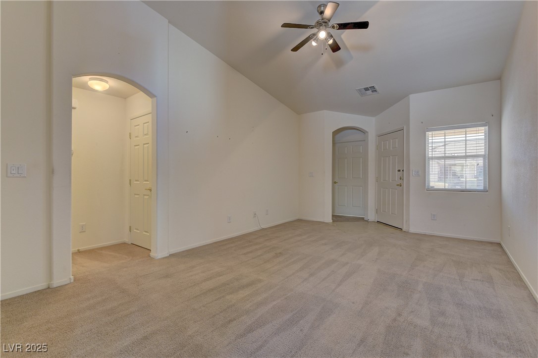 10403 Madagascar Palm Street Las Vegas, NV 89141 - Photo 7 of 21 Unfurnished room featuring light colored carpet, arched walkways, and ceiling fan
