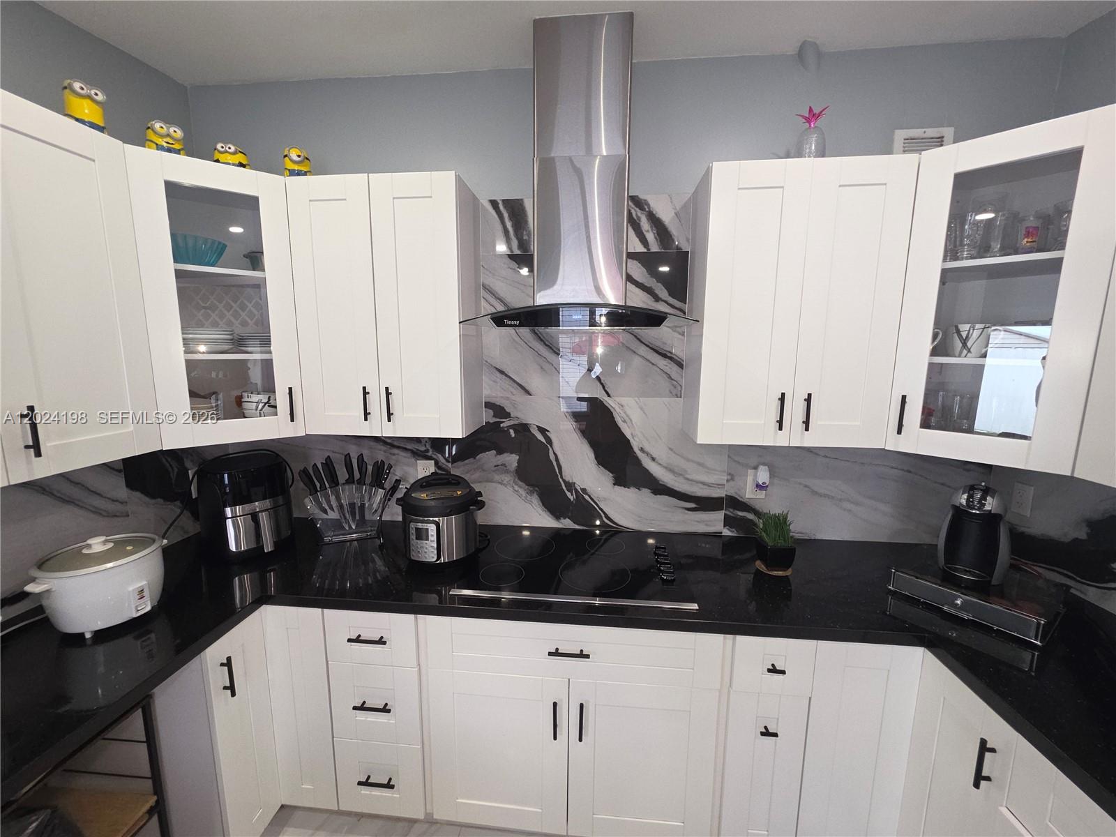 651 East 48th Street Hialeah, FL 33013 - Photo 17 of 52 a kitchen with a sink dishwasher and white cabinets