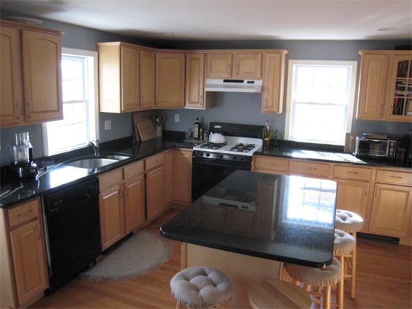 106 Desoto Road Boston, MA 02132 - Photo 4 of 27 a kitchen with stainless steel appliances granite countertop a stove a sink dishwasher a microwave oven and a dining table with wooden floor