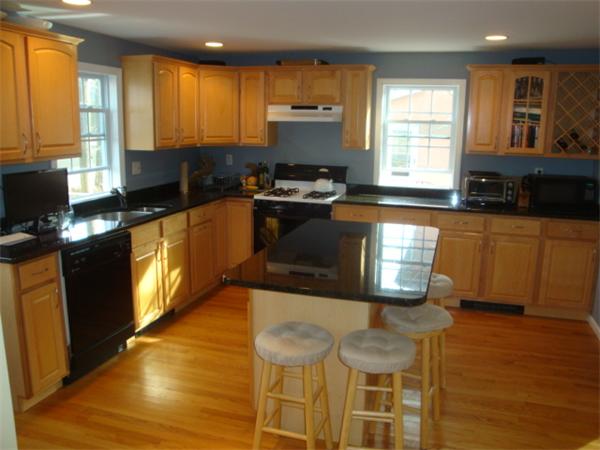 106 Desoto Road Boston, MA 02132 - Photo 6 of 27 a kitchen with granite countertop a stove a sink and a microwave