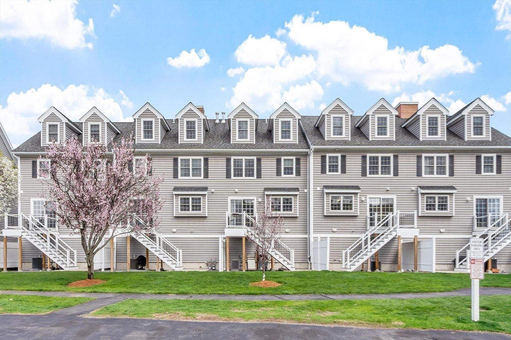 1975 Middlesex Street, Unit 33 Lowell, MA 01851 - Photo 17 of 18 a front view of a residential apartment building with a yard
