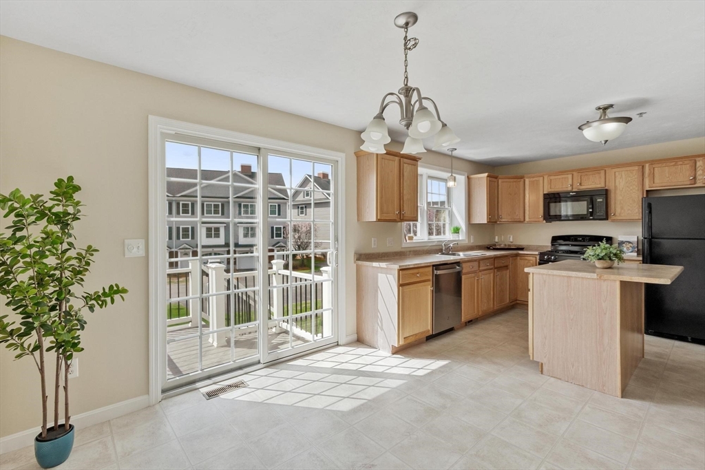 1975 Middlesex Street, Unit 33 Lowell, MA 01851 - Photo 4 of 18 a open kitchen that has a lot of cabinets appliances and a chandelier