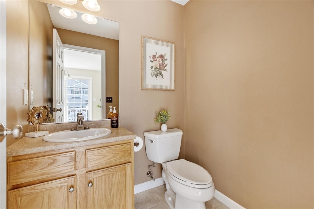 1975 Middlesex Street, Unit 33 Lowell, MA 01851 - Photo 5 of 18 a bathroom with a granite countertop toilet sink and mirror