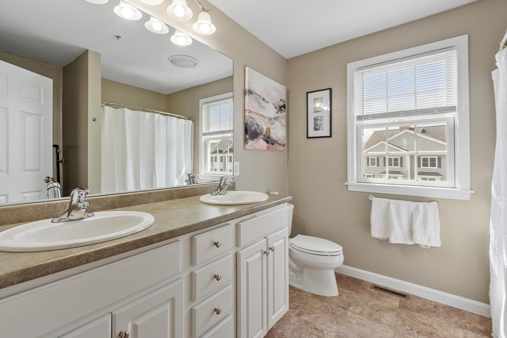1975 Middlesex Street, Unit 33 Lowell, MA 01851 - Photo 8 of 18 a bathroom with a granite countertop sink a toilet and a mirror