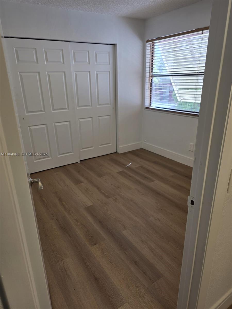 10951 Cypress Road, Unit 10951 Pembroke Pines, FL 33026 - Photo 16 of 27 a view of an empty room with wooden floor and a window