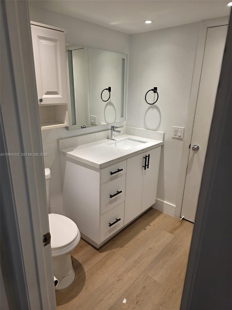 10951 Cypress Road, Unit 10951 Pembroke Pines, FL 33026 - Photo 21 of 27 a bathroom with a sink a toilet a mirror and vanity
