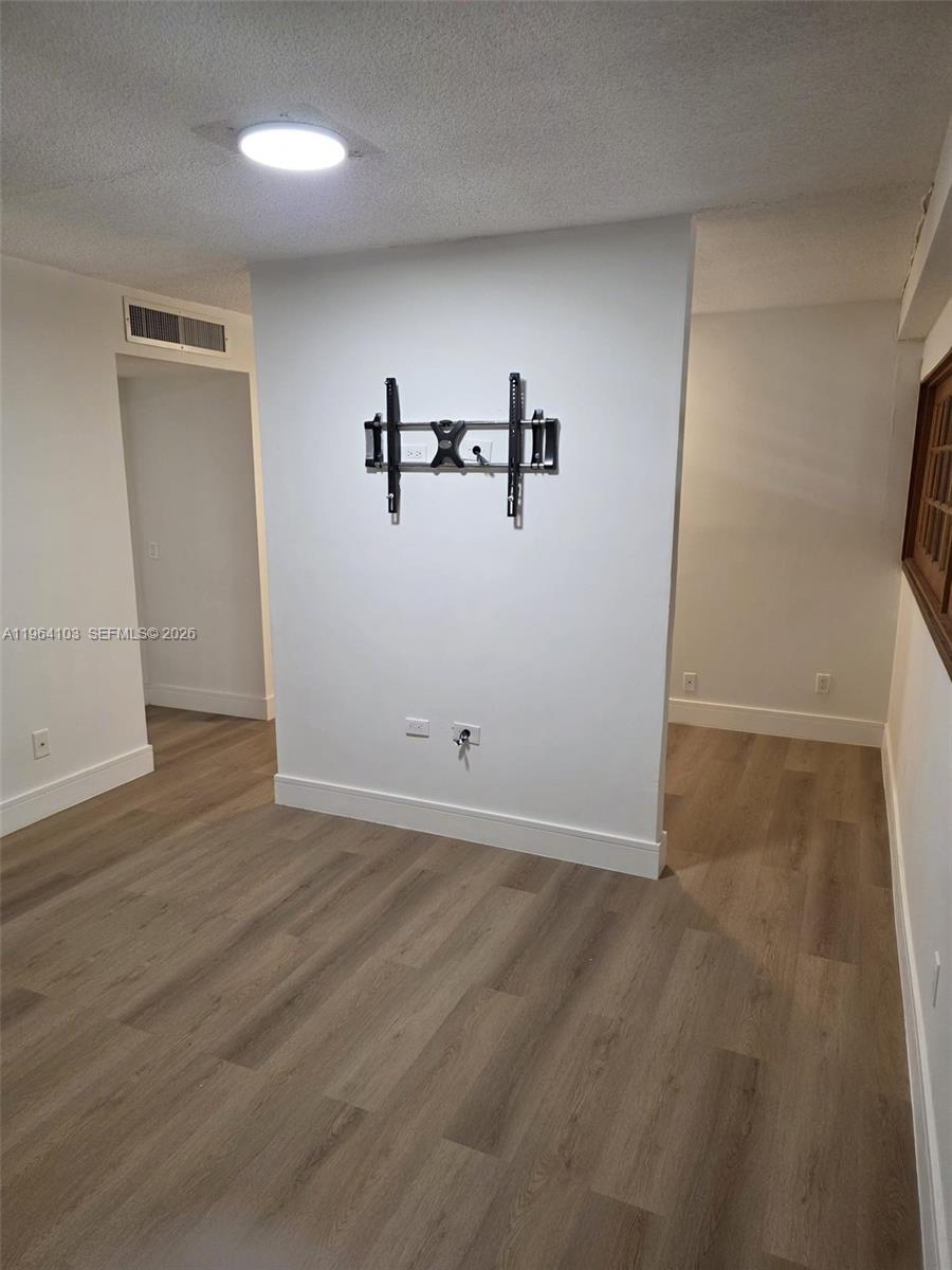 10951 Cypress Road, Unit 10951 Pembroke Pines, FL 33026 - Photo 22 of 27 an empty room with wooden floor and windows