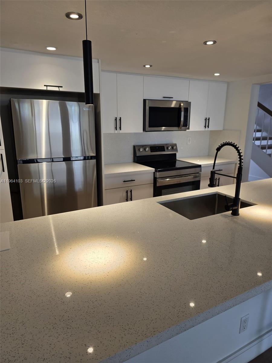 10951 Cypress Road, Unit 10951 Pembroke Pines, FL 33026 - Photo 5 of 27 a kitchen with stainless steel appliances a refrigerator sink and microwave