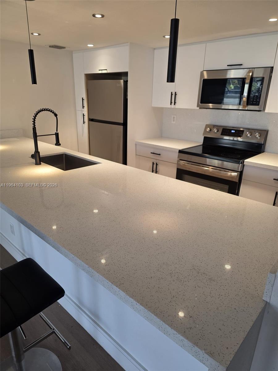 10951 Cypress Road, Unit 10951 Pembroke Pines, FL 33026 - Photo 6 of 27 a kitchen with a refrigerator and a stove top oven