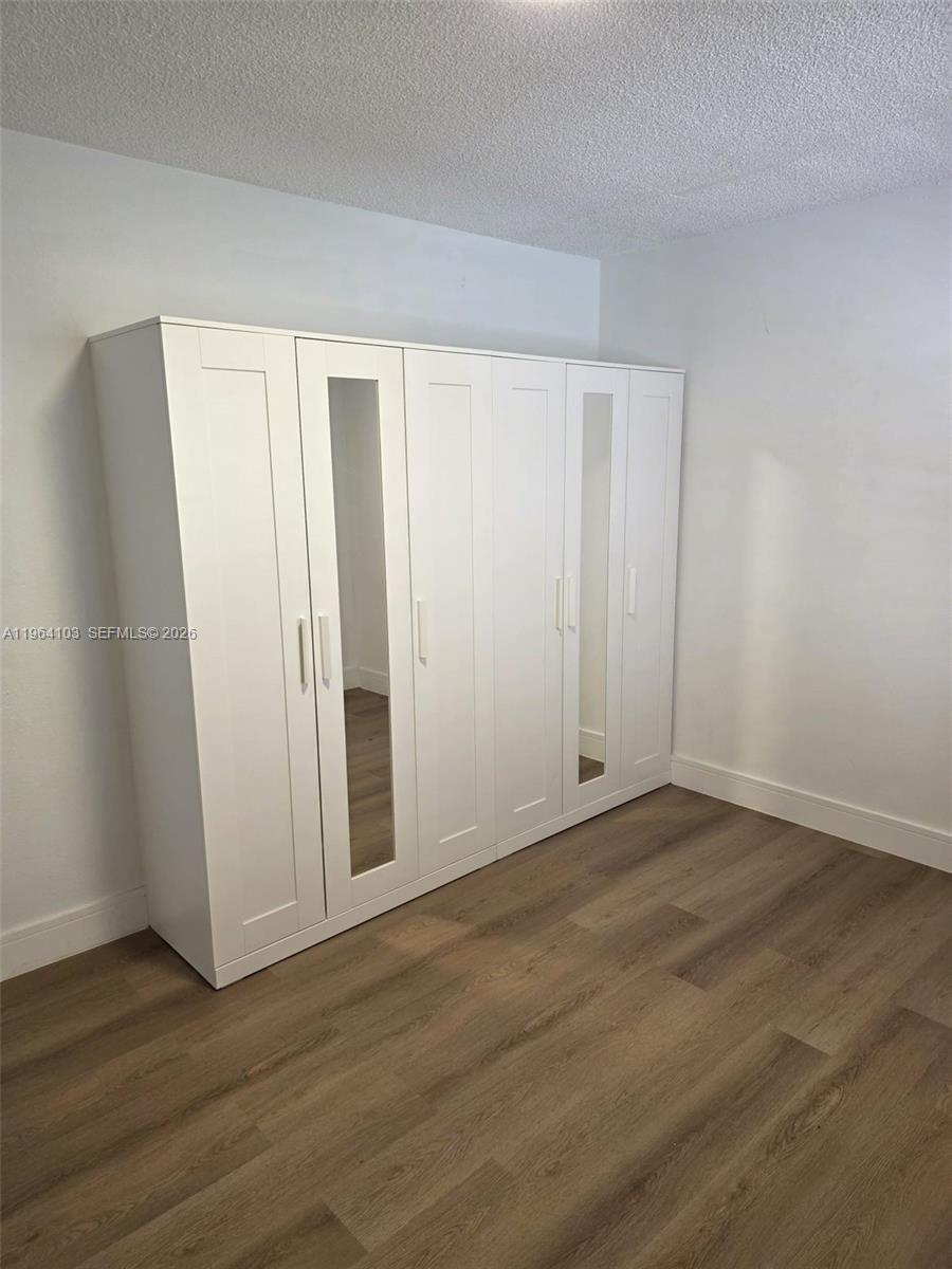 10951 Cypress Road, Unit 10951 Pembroke Pines, FL 33026 - Photo 8 of 27 a view of an empty room with wooden floor and closet