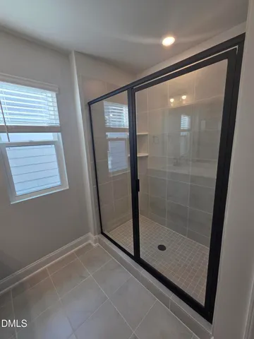 a bathroom with a granite countertop sink a mirror and a shower