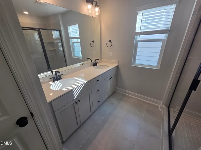 a bathroom with a double vanity sink toilet and a mirror