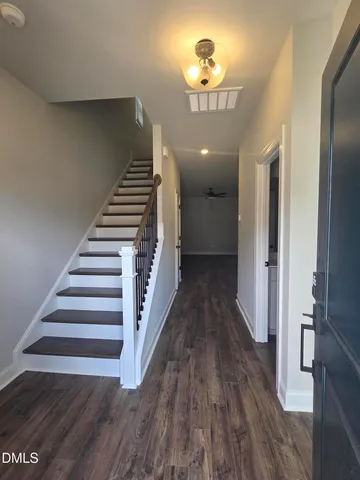 a view of a hallway with wooden floor and stairs