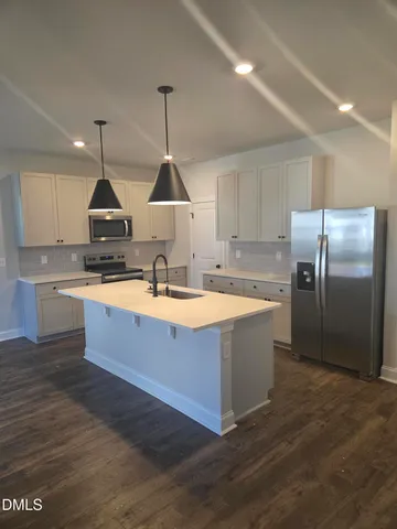 a kitchen with stainless steel appliances granite countertop a sink a stove and a refrigerator